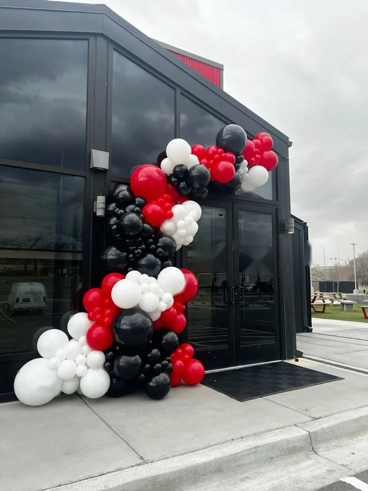 Red, black and white balloon garland at a building entrance